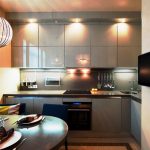 Gray kitchen cabinets up to the ceiling with lighting