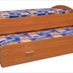Chipboard bed na may maaaring iurong na bahagi