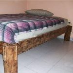 The legs of the bed are made of a tree trunk