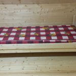 Pojedyncze drewniane łóżko w drewnianym pokoju zrób to sam