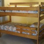 Simple wooden bed na may mga protective bed sa dalawang tier