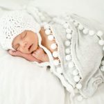 White blanket with pompoms for baby