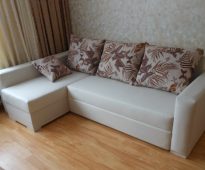 Biała narożna sofa z jasnymi poduszkami zrób to sam