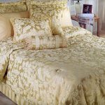 Dekorativt lock på en säng i beige-gyllene färg