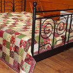 A colorful quilted bedspread in a rustic style.