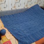 Duży niebieski dzianinowy koc zmieści się na łóżku lub sofie