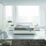 Modern white bedroom na may kama sa pamamagitan ng panoramic window