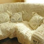 Bright handmade knitted coverlet on the sofa
