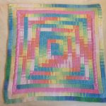 Bright square rug and colored yarn