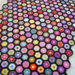 Unusual floral bedspread with multicolored knitted flowers