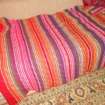 Original multi-colored blanket on the bed