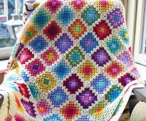 Multicolored squares of leftover yarn on a white background