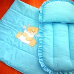 Küçük bir battaniye ve beşik veya bebek arabası için minder bulunan bir yatak