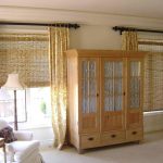 Wooden wardrobe sa pagitan ng mga window ng living room