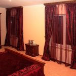Burgundy curtains, tulle at bedspread para sa light bedroom