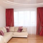 Burgundy curtains in the interior of the living room in bright colors