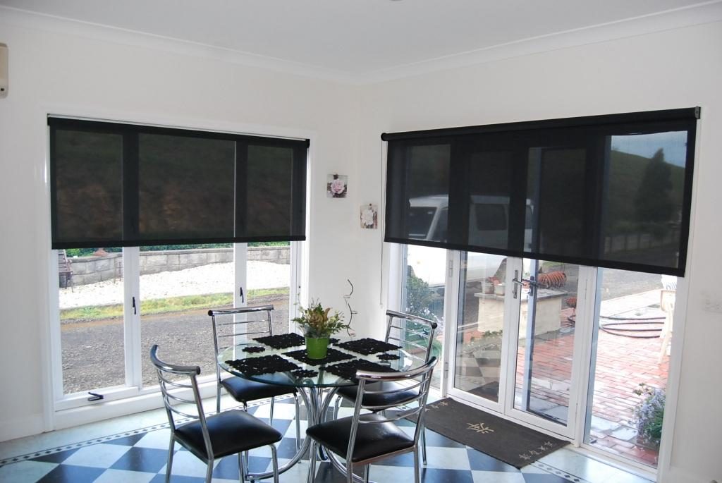 Translucent black curtains on the kitchen window with white walls