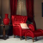 Long maroon curtains na may mga hook at tulle sa red furniture