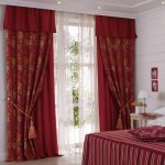 Double burgundy curtains with lambrequin grabs and tulle in the bedroom