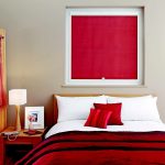 Czerwona zasłona z mechanizmem sprężynowym we wnętrzu sypialni