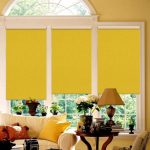 Yellow roll-up curtains on the arched window