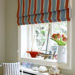 Striped roller blinds cover the window sill and the window entirely