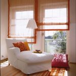 Translucent orange roman blinds fixed to the wall