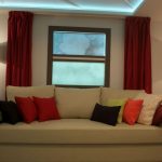 Ceiling maroon curtains to a beige sofa