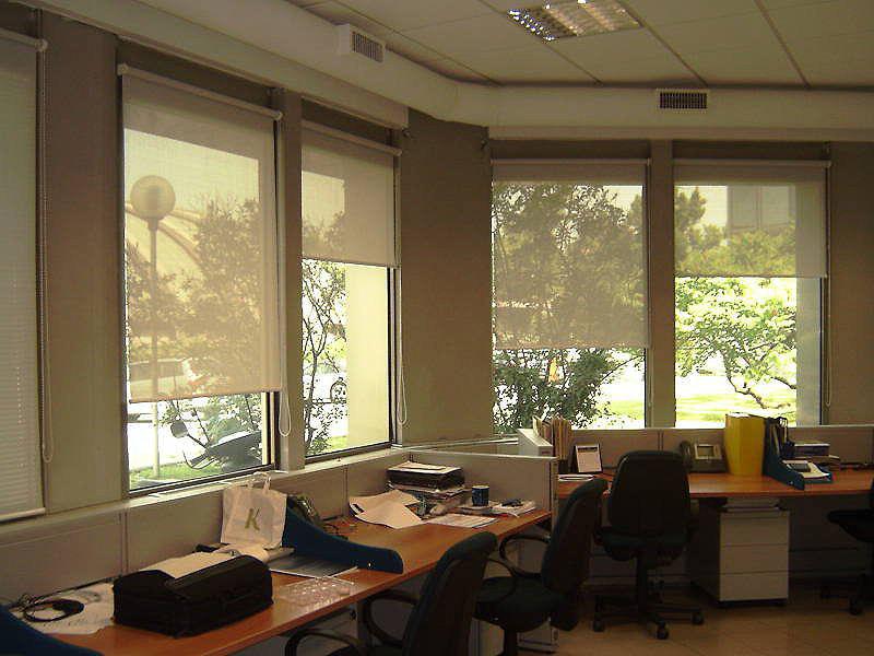 Pienen toimiston ikkunat, joissa on rullaverhot