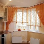 Kuhinjski prozorski ukras s narančastim zavjesama