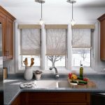 Rolled curtains of natural material on the doors of the kitchen window