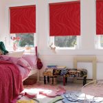 Røde gardiner på vinduerne i soveværelset til pigen