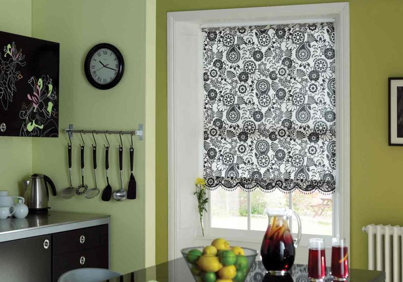 Rullegardin med färgstark svartvit prydnad på köksfönstret