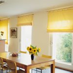 Valjane zavjese u žutoj boji na kuhinji s pričvršćivanjem na strehu