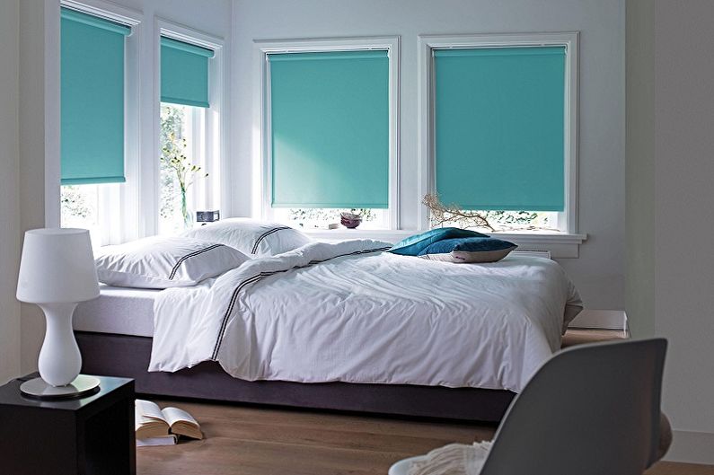 Turquoise curtains of thick material on the windows of the bedroom