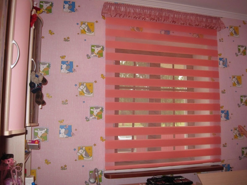 الستائر الوردية حمار وحشي في غرفة فتاة في سن ما قبل المدرسة.
