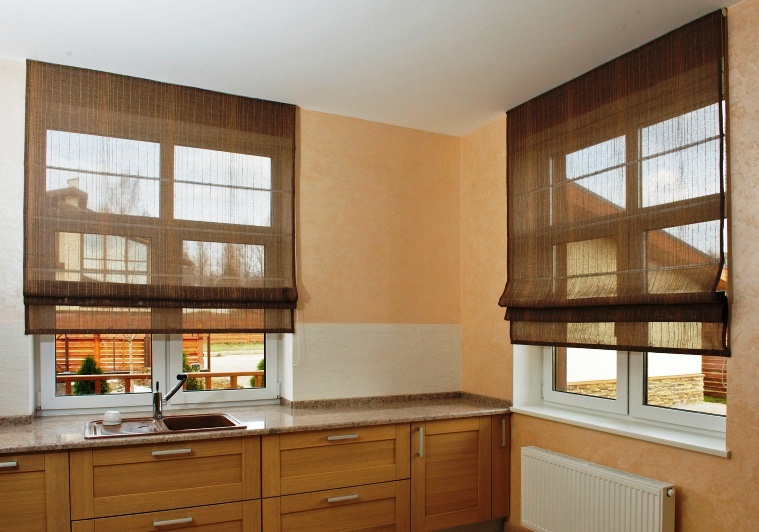 Průsvitné syntetické závěsy římského typu na oknech v kuchyni