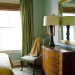 Eklektisessä tyylisessä makuuhuoneessa on vihreät verhot ja seinät.