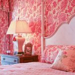 غرفة نوم مع ورق الحائط والستائر ذات اللون الوردي ، تكملها نمط الأزهار