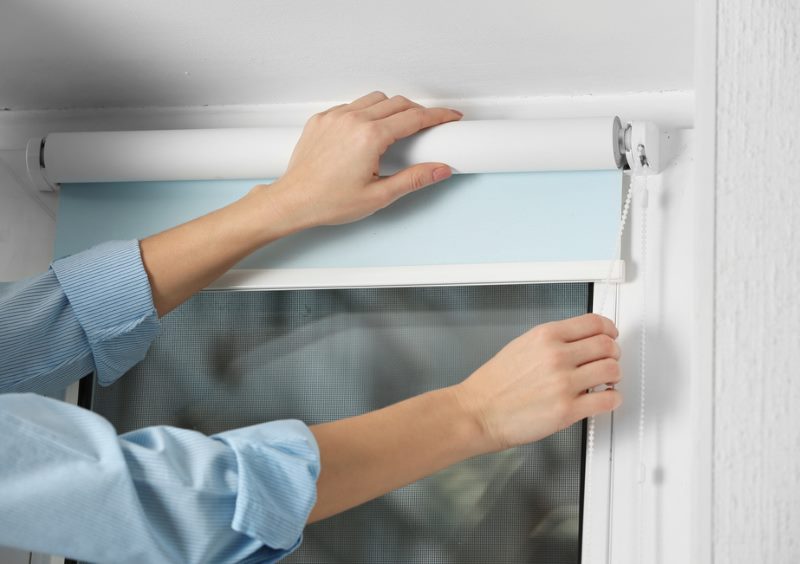 Installing a curtain with your hands on the PVC window