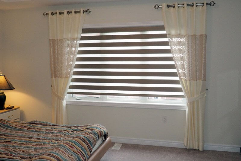 Połączenie zasłon zebry z prostymi zasłonami w oknie sypialni