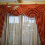 White curtain with gold pattern and red curtains with lambrequin