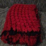Large plaid of pompons in red and black colors
