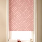 A window in the children's room with a polka dot curtain