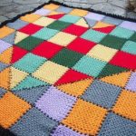 Beautiful bedspread of squares and triangles with a pattern in the shape of a heart