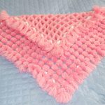 Soft pink plaid with pompons for a newborn