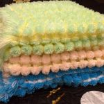 Veelkleurige dekens van pompons doen het zelf