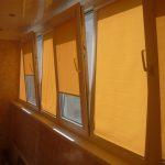 Żółte okiennice na skrzydle okna balkonowego