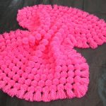 Pink plaid of pompons suitable for an extract for the girl
