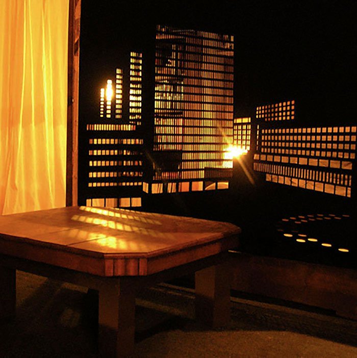 Drewniany stół przy oknie z zaciemnioną perforowaną zasłoną